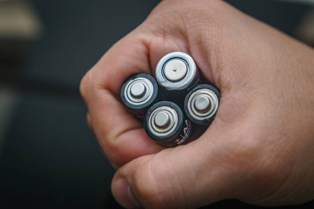 One single hand holding batteries stock photo