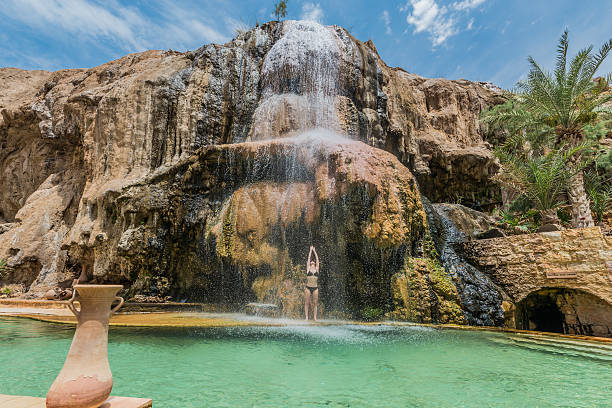one woman bathing ma'in hot springs waterfall jordan one woman bathing at ma'in hot springs waterfall in jordan middle east hot middle eastern women stock pictures, royalty-free photos & images