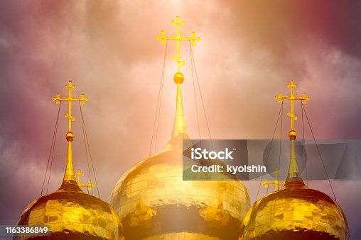 istock Onion dome of traditional russian church. Golden cupola with crosses, sun shining and dramatic sky in background. 1163386849