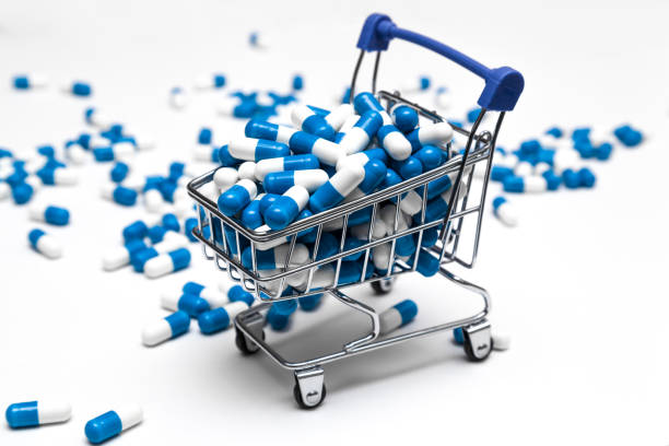 online medicine shopping concept online medicine shopping concept, supermarket trolley full of medicines, blue white capsules buy medicine online stock pictures, royalty-free photos & images