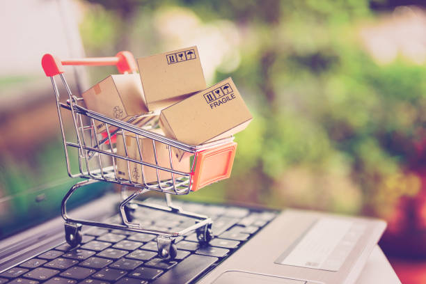 online shopping and delivery service concept. paper cartons in a shopping cart on a laptop keyboard, this image implies online shopping that customer order things from retailer sites via the internet. - balcão computador imagens e fotografias de stock