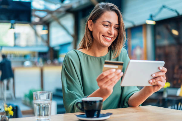 Online shopping Young woman shopping online in cafe using digital tablet and credit card credit card purchase stock pictures, royalty-free photos & images