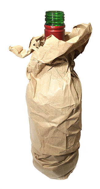 open alcohol bottle in a brown paper bag stock photo