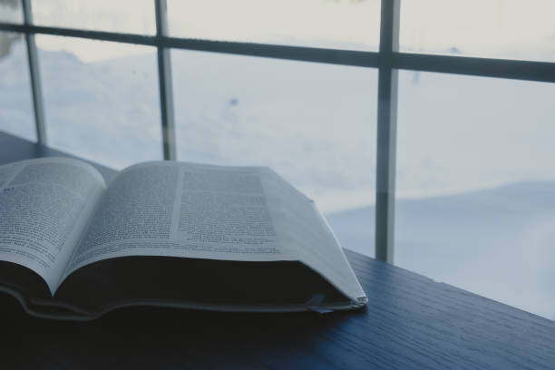 Open bible and snow out a window stock photo