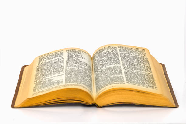 Open bible on plain white background with yellowed pages stock photo