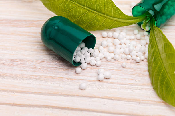 Open capsule with small white specs and green leaf stock photo