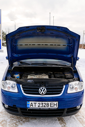 Valley, Ukraine December 22, 2021: details and parts of the body of a Volkswagen Touran close-up, blue car, open car hood