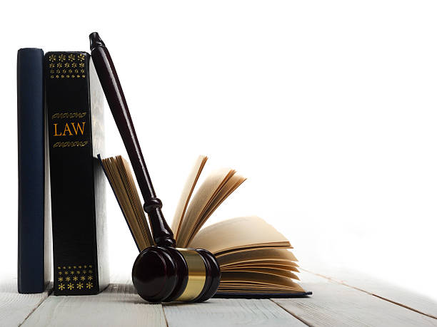 Open law book with wooden judges gavel on table in stock photo