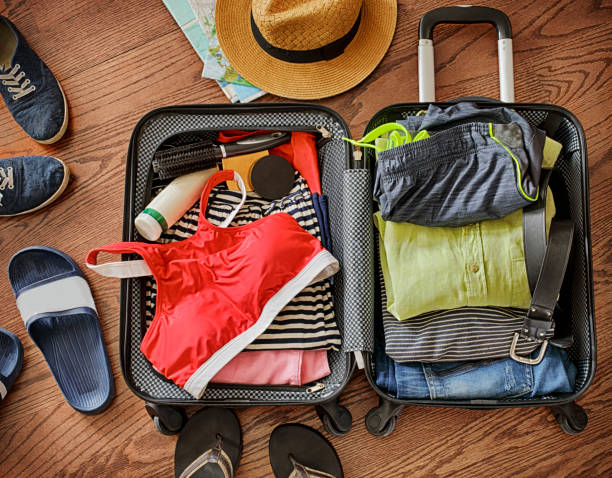 Open traveler's bag with clothing, accessories, and passport. Travel and vacations concept stock photo