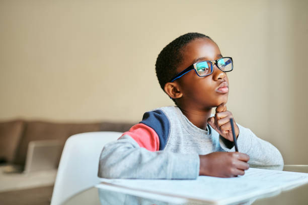 Open your mind to knowledge Shot of an adorable little boy doing his schoolwork at home student photos stock pictures, royalty-free photos & images