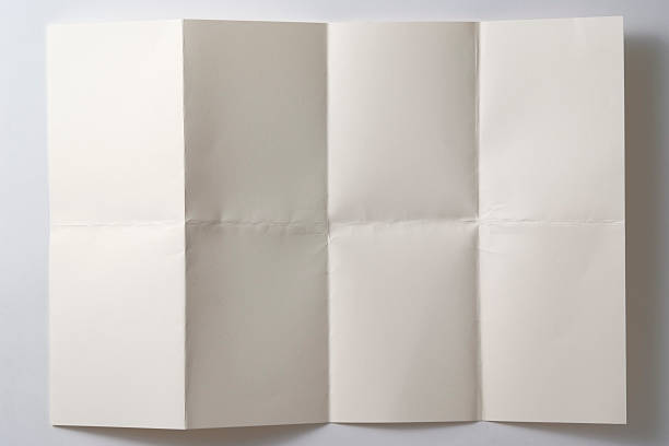 Opened a folded paper on white background with shadow Overhead shot of opened a folded paper  folded photos stock pictures, royalty-free photos & images