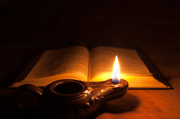 opened-bible-and-oil-lamp-picture-id154394758