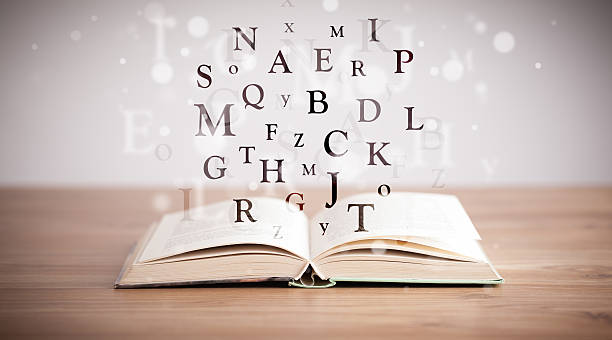 Opened book with flying letters stock photo