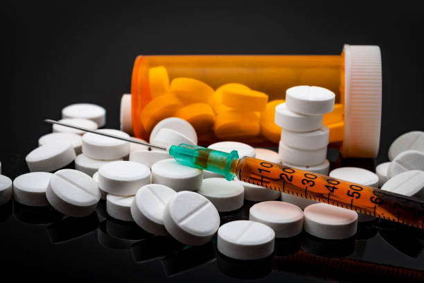 Opioid epidemic and drug abuse concept Opioid epidemic and drug abuse concept with a heroin syringe or other narcotic substances next to a bottle of prescription opioids. Oxycodone is the generic name for a range of opioid painkillers heroin stock pictures, royalty-free photos & images