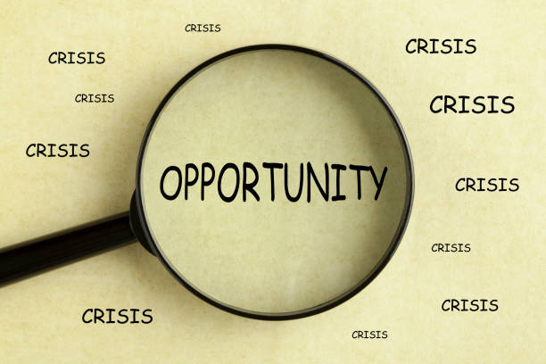 Opportunity Crisis Concept Magnifying glass over the word opportunityon and crisis concept background opportunity stock pictures, royalty-free photos & images