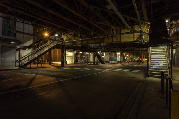 Opposite stairwells leading up to overhead subway trains at night in downtown Chicago stock photo