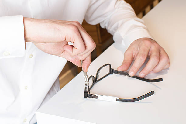 Optician repairs eyeglasses stock photo