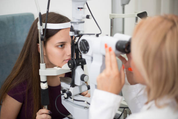 Optometrist checking young patient vision at eye clinic. stock photo