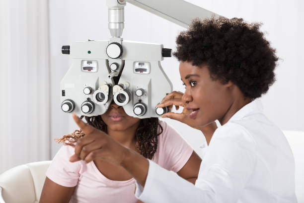 Optometrist Doing Sight Testing For Patient Female African Optometrist Doing Sight Testing For Patient In Hospital eye doctor stock pictures, royalty-free photos & images