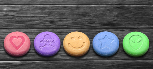 MDMA or Ecstasy pills on dark wooden background MDMA or Ecstasy pills on dark wooden background mephedrone stock pictures, royalty-free photos & images