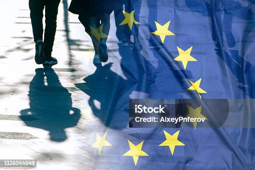 istock EU or European Union Flag and shadows of people, concept political picture 1326044649