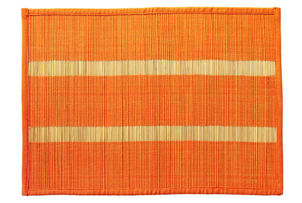 tappeto di cibo di bambù intrecciato arancione preso primo piano isolato su sfondo bianco. - tovaglietta foto e immagini stock
