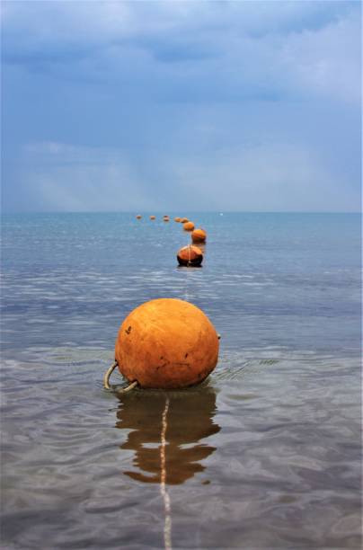 orange buoys in blue water sea stock photo