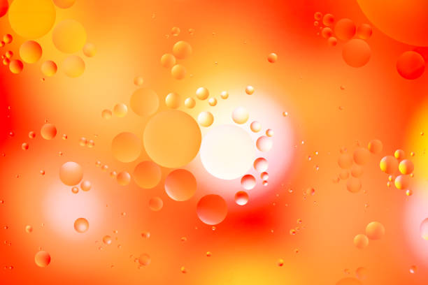 Orange circles of drops of oil floating on water stock photo