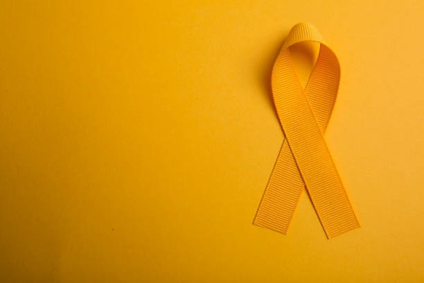 Orange colored ribbon isolated on orange background. Symbol of leukemia cancer awareness. healthcare and medicine concept. Preventive measures for health stock photo