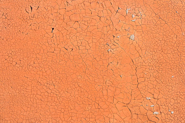 Orange cracked paint on the concrete wall stock photo