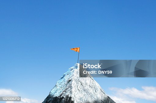 istock Orange Flag Planted on Top Of Snow Capped Peak 1321335712