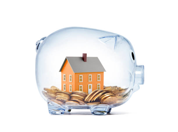 Orange house on money inside transparent piggy bank with clipping path stock photo