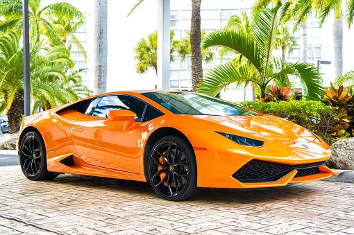 Miami, Florida, United States - February 19, 2016: Supercar Lamborghini Aventador orange color parked next to Ocean drive at South bech at Miami, Florida. Lamborghini is famous expensive automobile brand car