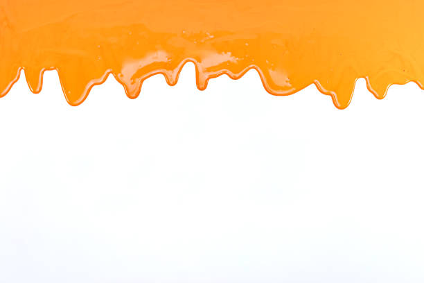 orange paint flows on white background stock photo