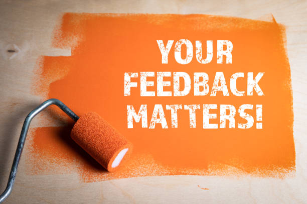 YOUR FEEDBACK MATTERS. Orange painted wooden surface stock photo