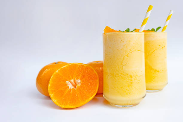 Orange smoothies morning drinks on a healthy summer vacation on a wooden or white background. Orange smoothies morning drinks on a healthy summer vacation on a wooden or white background. orange smoothie stock pictures, royalty-free photos & images