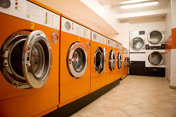 Orange washers at a laundromat stock photo