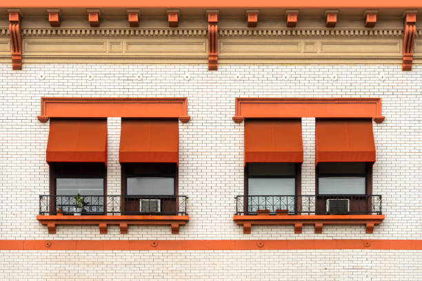 Orange window awnings on a white brick building  awning window stock pictures, royalty-free photos & images