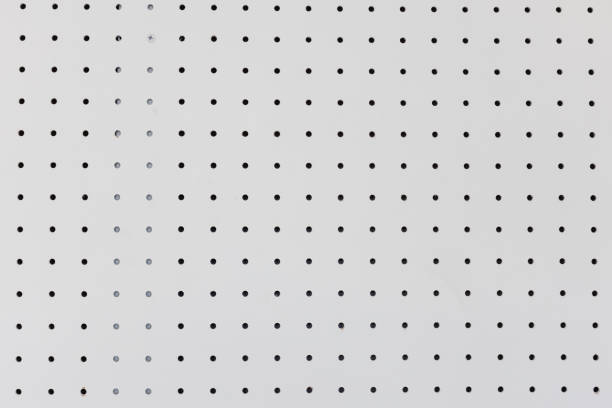 orderly dot or holes rows and columns on white pegboard wall. orderly holes or dot rows and columns on white pegboard wall. pegboard stock pictures, royalty-free photos & images