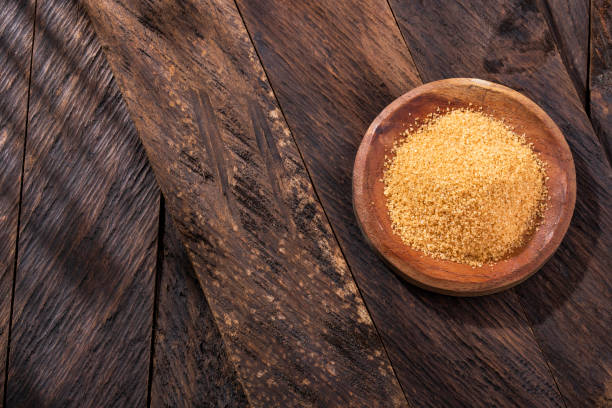 Organic brown sugar in the wooden bowl - Saccharum officinarum stock photo