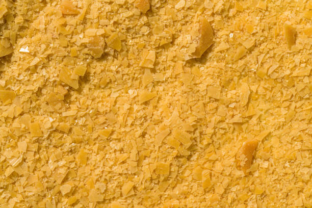 Organic Carnauba Wax come in the form of hard yellow flakes and is widely used in cosmetics as an emulsifier or as a thickening agent for lipstick, eyeliner, mascara, eye shadow, foundation, deodorant stock photo