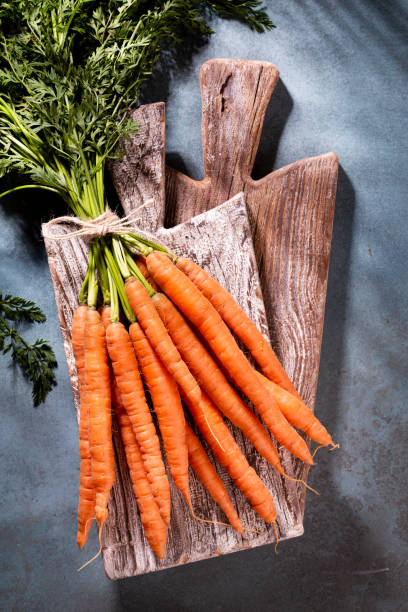 Organic carrot on wood cutting board, closeup photo. stock photo