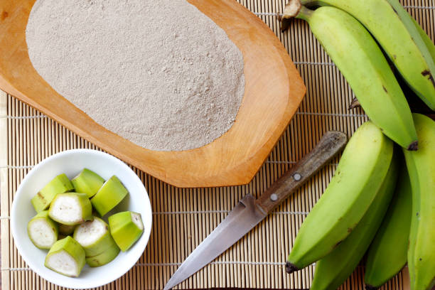 Organic green banana flour, crushed, raw and dry in wooden bowl. gluten free flour stock photo