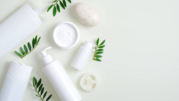Organic herbal cosmetic products on green background. Top view beauty spa cosmetic bottle packaging, hand cream, lotion, bath sponge, natural soap and green leaves. Minimalist beauty product mockups  products stock pictures, royalty-free photos & images
