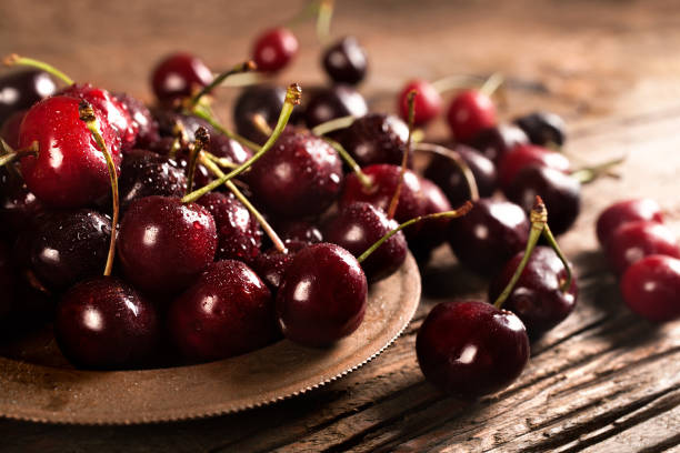 Organic red cherries in a rustic bowl stock photo