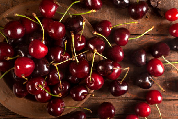 Organic red cherries in rustic plate stock photo