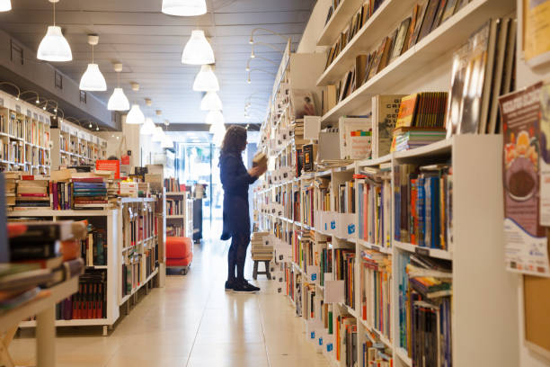 書店で棚を整理する - 本を買う ストックフォトと画像