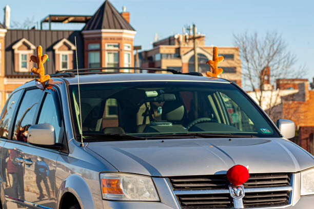 Ornamental antlers on windows and a red nose decor on the front panel of a car. stock photo