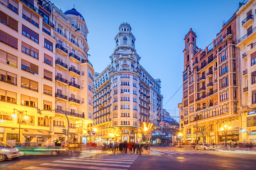Ornate facades and towers in downtown Valencia Spain at twilight blue hour.