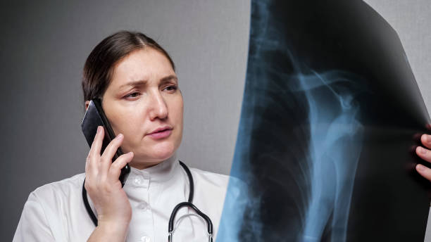 Orthopedist reports results of x-ray examination on phone stock photo